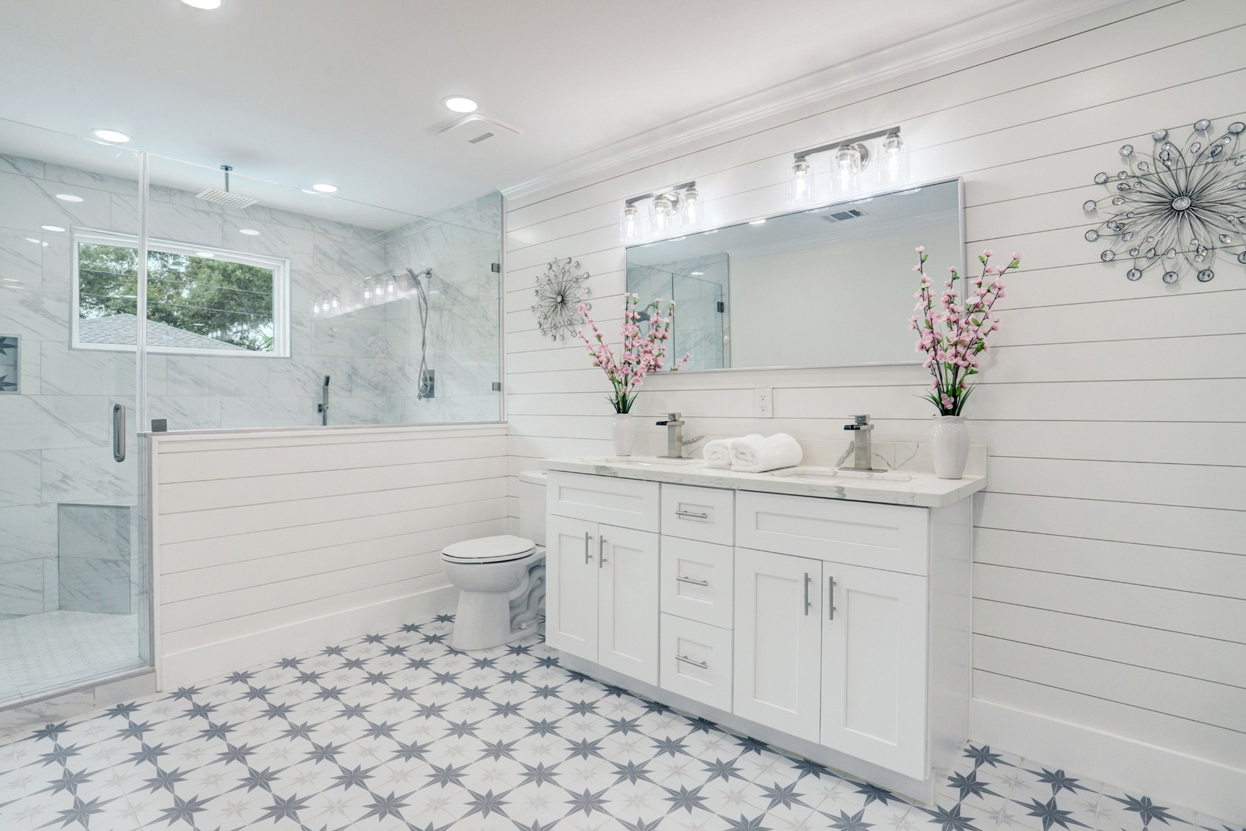 Bright complete bathroom remodel with double vanity and custom shower