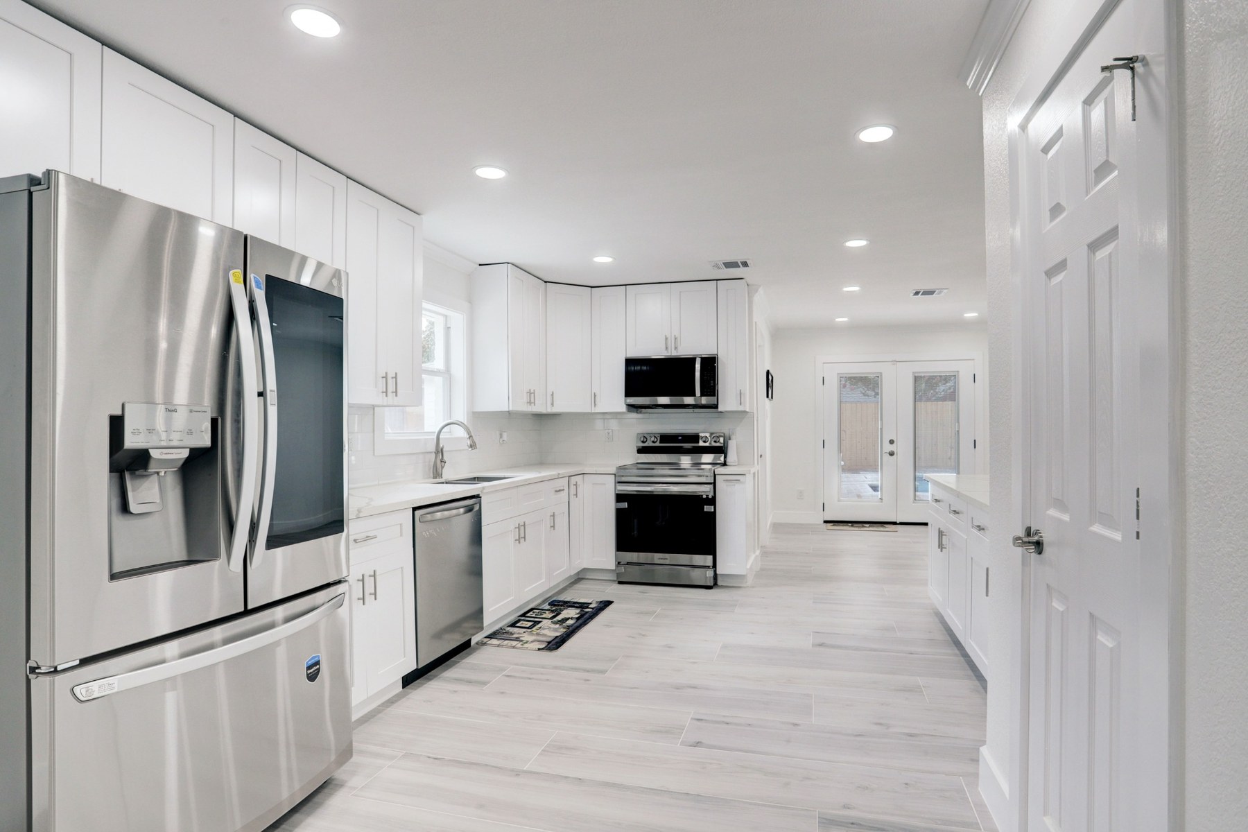 White kitchen renovation with stainless steel appliances