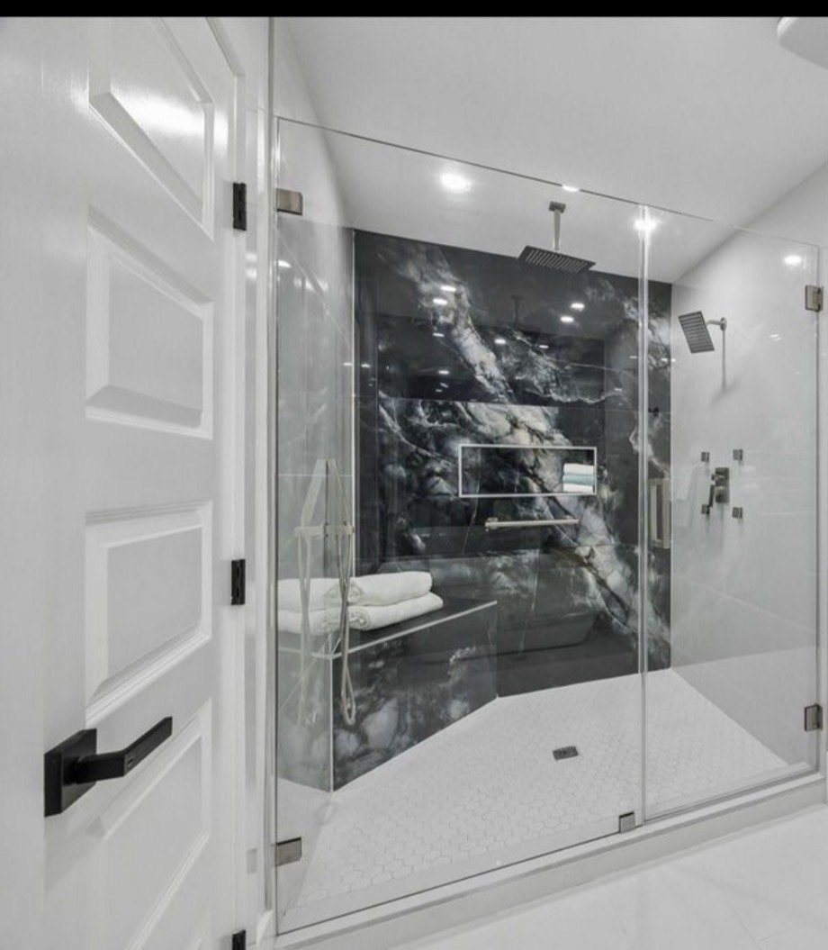 Custom shower with multiple fixtures and glass enclosure
